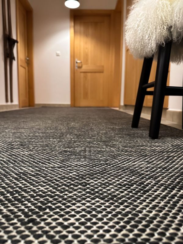 Projet d'aménagement et de décoration d'appartement de montagne Haute -Nendaz - Couloir avec tapis Bomat et tabourets Tibet